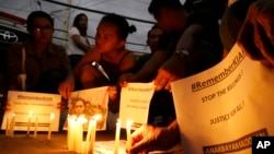 Activists hold candles in front of the picture of murdered 17-year-old student Kian Loyd delos Santos in Caloocan, metropolitan Manila, Philippines on Nov. 29, 2018. 