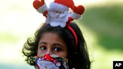 سری لنکا کی ایک بچی نے سانتا کلاز کا ربن باندھ رکھا ہے۔ 
