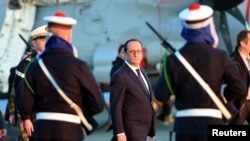 French President Francois Hollande reviews troops during his visit aboard French aircraft carrier Charles de Gaulle January 14, 2015, off the coast of Toulon, southern France.