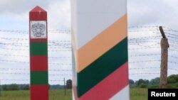 Lithuanian (R) and Russian border signs are seen near the Sudargas border crossing point with Russia in Ramoniskiai, Lithuania, June 5, 2017.