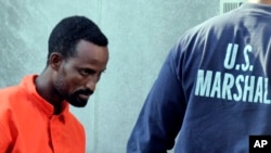 FILE - A suspected pirate from Somalia is escorted into federal court by U.S. Marshals in Norfolk, Virginia, April 23, 2010. Three pirates received sentences on Tuesday.