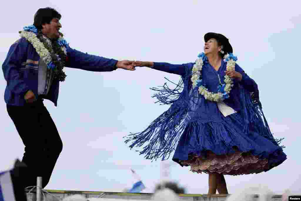 Bolivia&#39;s President and current presidential candidate for the Movement for Socialism (MAS) party Evo Morales, left, dances during a closing campaign rally in El Alto, Oct. 16, 2019.