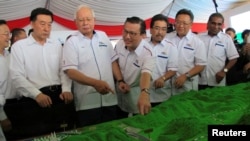 Malaysia's Prime Minister Najib Razak and Transport Minister Liow Tiong Lai look at a model of the East Coast Rail Line at Kuantan Bahang, Malaysia, Aug. 9, 2017.