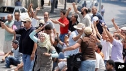 Demonstrators shout slogans as they clash with Tunisian security forces in La Kasbah square, July 15, 2011