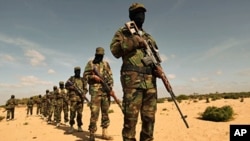 Members of Somalia's al-Shabaab militant group parade during a demonstration to announce integration with al Qaida, in Elasha, south of the capital Mogadishu, February 13, 2012