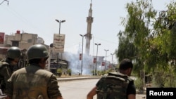 Syrian army soldiers run after a bomb exploded on a street in the town of Douma near Damascus, May 20, 2012.