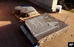 FILE - The damaged remains of a Ten Commandments monument lie on the capitol grounds in Oklahoma City after driver Michael Tate Reed of Van Buren, Ark., crashed into the statue, Oct. 24, 2014.