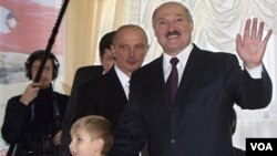 Presiden terpilih Belarusia Alexander Lukashenko bersama anaknya Nikolai di tempat pemilihan di kota Minsk.