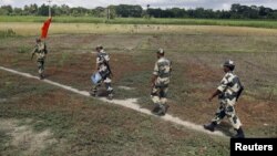 FILE - Indian Border Security Force soldiers walk across the open border with Bangladesh to attend a flag meeting in West Bengal, India, June 20, 2015. Indian officials said Sept. 23, 2017, that because of security risks, border forces have been authorized to prevent Rohingya Muslims from entering the country.