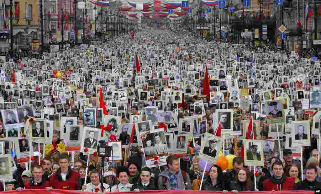 Warga setempat membawa potret para leluhur mereka yang ikut dalam Perang Dunia II, dalam merayakan Hari Kemenangan di St. Petersburg, Rusia. Sekitar 30.000 orang berbaris&nbsp; dalam parade &quot;Resimen Abadi&quot; Hari Kemenangan, yang menandai kekalahan Nazi Jerman. Peringatan tersebut&nbsp; adalah perayaan sekuler paling penting di Rusia. &nbsp;