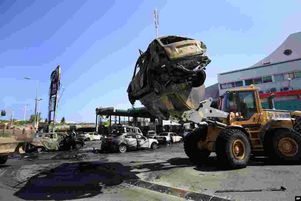 Destroyed cars are removed from a gas station that was hit by a rocket fired from the Gaza Strip in the city of Ashdod, Israel, July 11, 2014. 