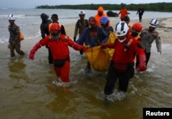 Rescue workers carry a body bag containing the remains of a victim of a tsunami at Tanjung Lesung in Pandeglang, Banten province, Indonesia, Dec. 25, 2018.