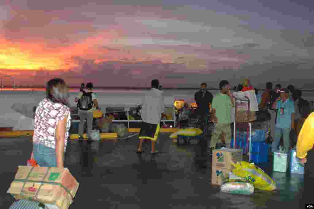 Boarding a ferry at dusk at Cebu pier for Leyte with relief supplies, Philippines, Nov. 17, 2013. (Steve Herman/VOA)