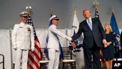 El presidente Donald Trump (derecha) estrecha la mano del almirante Paul Zukunft (centro) durante la ceremonia de cambio de mando en la Guardia Costera de EE.UU. en Washington el viernes, 1 de junio, de 2018.
