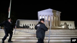 Supreme Court police officers move a barricade in front of the U.S. Supreme Court, Feb. 19, 2016 in Washington. 