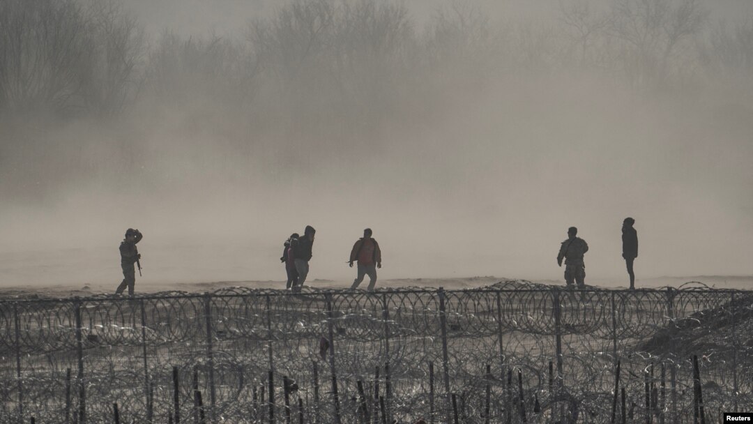 ARCHIVO: Un grupo de migrantes es detenido por miembros de la Guardia Nacional de Estados Unidos en Eagle Pass, Texas, visto desde Piedras Negras, México, el 4 de febrero de 2024.