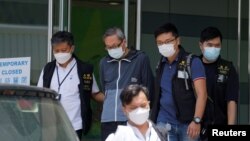 2021 年 6 月 17 日，香港警方國安處的警察在壹傳媒總部拘捕了蘋果日報行政總裁張劍虹 （路透社照片） 