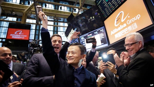 阿里巴巴的创始人马云(中)在公司在纽约证券交易所进行首次公开募股(IPO)时，举起了敲钟用的槌子（2014年9月19日）。
