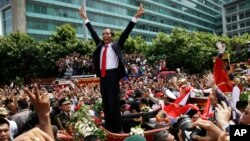 Indonesian President Joko Widodo gestures to the crowd during a street parade following his inauguration in Jakarta, Indonesia, Oct. 20, 2014. (AP Photo/Achmad Ibraham)