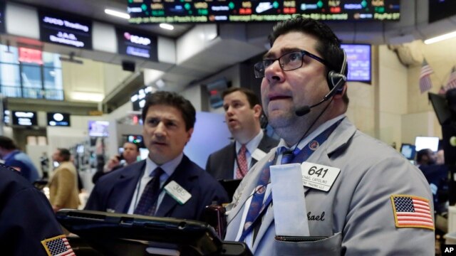 Corredores en la Bolsa de Nueva York miran preocupados la abrupta declinación de las acciones energéticas mientras el precio del petróleo continúa bajando. Enero 20, 2016.