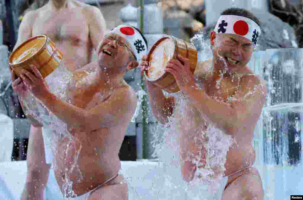 Men pour cold water over themselves during the annual cold water endurance ceremony, to purify their souls and wish for good fortune in the new year, at the Kanda Myojin shrine in Tokyo, Japan, Jan. 13, 2018.