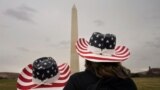 Tourists in patriotic cowboy hats visit the Washington Monument