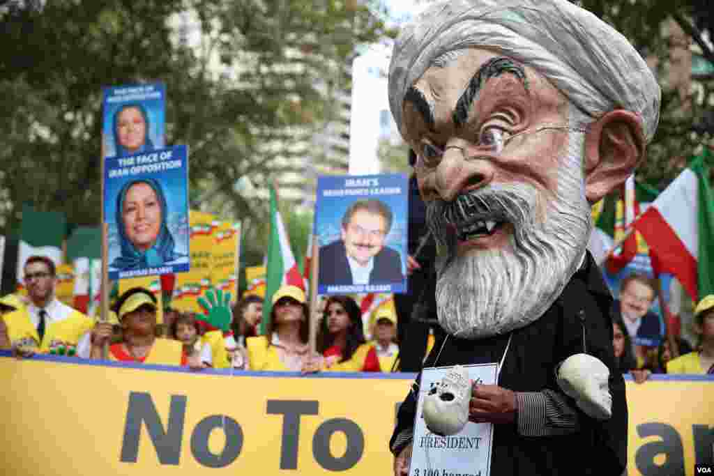 معترضان در زمان سخنرانی روحانی در نیویورک عکس هایی از مریم و مسعود رجوی، رهبران مجاهدین خلق را حمل می کردند.
