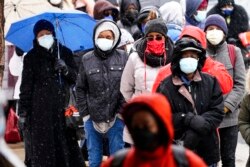 Orang-orang mengantre di klinik vaksinasi COVID-19 24 jam yang diselenggarakan oleh Konsorsium Dokter Hitam COVID-19 di Pusat Liacouras Temple University di Philadelphia, 19 Februari 2021. (Foto: AP)