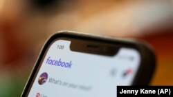 In this August 11, 2019, file photo an iPhone displays a Facebook page in New Orleans. A Ukrainian security researcher says a database with the names, phone numbers and unique user IDs of more than 267 million Facebook users was exposed on the internet. (AP Photo/Jenny Kane)