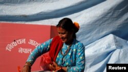 A woman smiles as she cast her vote on a ballot box during the parliamentary and provincial elections in Sindhupalchok District, Nepal, Nov. 26, 2017.
