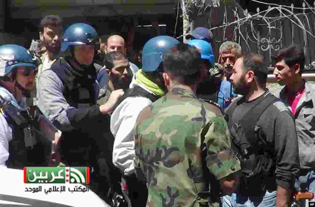 This citizen journalism image provided by the United media office of Arbeen shows U.N. investigators in a suburb of Damascus, August 28, 2013.