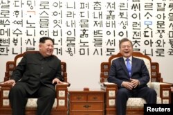 Presiden Korea Selatan Moon Jae-in berbincang dengan pemimpin Korea Utara Kim Jong-un (kiri) selama pertemuan mereka di Wisma Perdamaian (Peace House) di desa gencatan senjata Panmunjom di dalam zona demiliterisasi yang memisahkan kedua Korea, Korea Selatan, 27 April 2018.