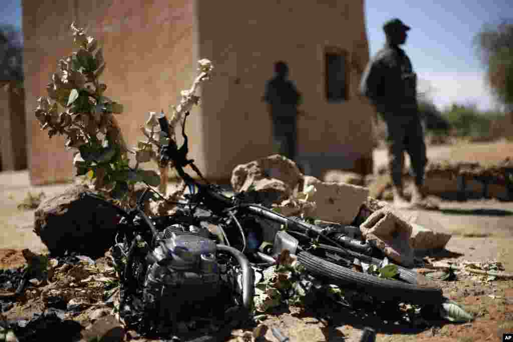 Malian soldiers stand by a motorcycle used by a suicide bomber at the entrance of Gao, northern Mali, Feb. 8, 2013.