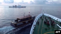 The Chinese Coast Guard shows a collision between a Chinese Coast Guard ship (R) and Philippines' resupply boat (L) during a resupply mission near the Second Thomas Shoal, in the disputed South Chi