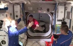 스페이스X 유인우주선 탑승 우주비행사 마이크 홉킨스가 17일 우주정거장에 도착한 후 기존 승무원 케이트 루빈스의 환영을 받고 있다.