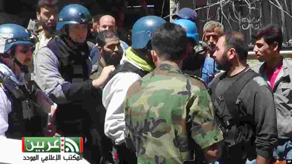 This citizen journalism image provided by the United media office of Arbeen shows U.N. investigators in a suburb of Damascus, August 28, 2013.