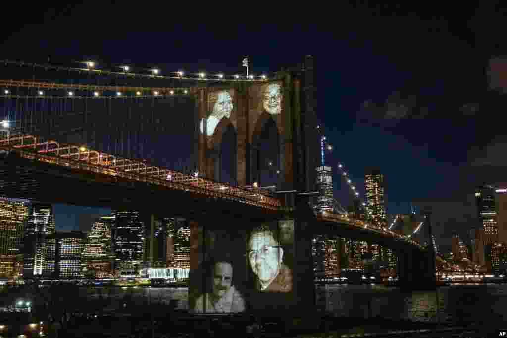 New Yorkers who died during the coronavirus pandemic are projected onto the Brooklyn Bridge during a commemoration ceremony, March 14, 2021, in Brooklyn.