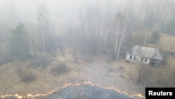An aerial view shows grass and plants on fire, as an operation to extinguish wildfires around the defunct Chernobyl nuclear plant continues, in Lyudvynivka in Kyiv Region, Ukraine, April 18, 2020. 