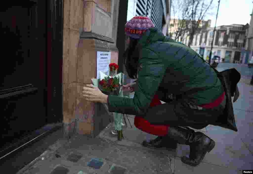 A woman places flowers as a tribute outside the Cuban Embassy in London, following the announcement of the death of Cuban revolutionary leader Fidel Castro, central London, Britain November 26, 2016.