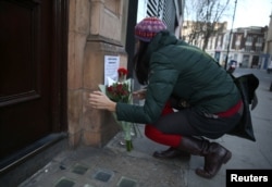 A woman places flowers as a tribute outside the Cuban Embassy in London, following the announcement of the death of Cuban revolutionary leader Fidel Castro, central London, Britain November 26, 2016.