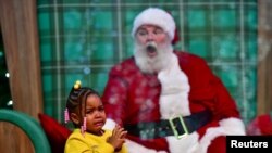 Majesty Davis, 3, menangis saat mengunjungi Santa Claus, yang duduk di belakang pembatas kaca plexiglass karena pandemi COVID-19, di Willow Grove Park Mall di Willow Grove, Pennsylvania, 14 November 2020. (Foto: Reuters)