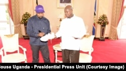 Kanye West autographs sneakers to Uganda President Yoweri Museni in State House Entebbe, Oct. 15, 2018.