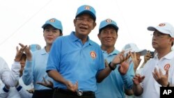 Cambodian Prime Minister Hun Sen, center, dances with his supporters during his Cambodian People's Party's last campaign for the July 29 general election, in Phnom Penh, Cambodia, July 27, 2018.