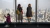 FILE - Visitors take selfies and pictures of the Tokyo skyline from the Roppongi Hills commercial complex, Jan. 20, 2018.