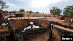 A man is seen inside a burnt house during clashes between nomads and residents in Deleij village, central Darfur, Sudan, June 11, 2019. 