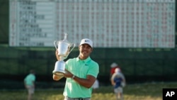 Brooks Koepka poses with the winning trophy after the U.S. Open golf tournament, June 18, 2017.