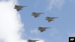 FILE - Taiwan's Mirage 2000 fighter jets fly in close formation over President Office during National Day celebrations in front of the Presidential Building in Taipei, Oct. 10, 2021.