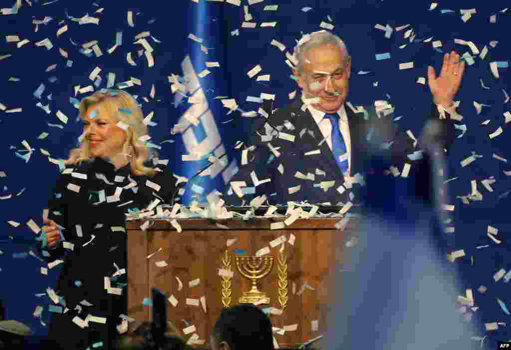 Israeli Prime Minister Benjamin Netanyahu and his wife, Sara, address supporters as confetti falls upon them at the Likud party campaign headquarters in the coastal city of Tel Aviv, after voting stations officially closed.