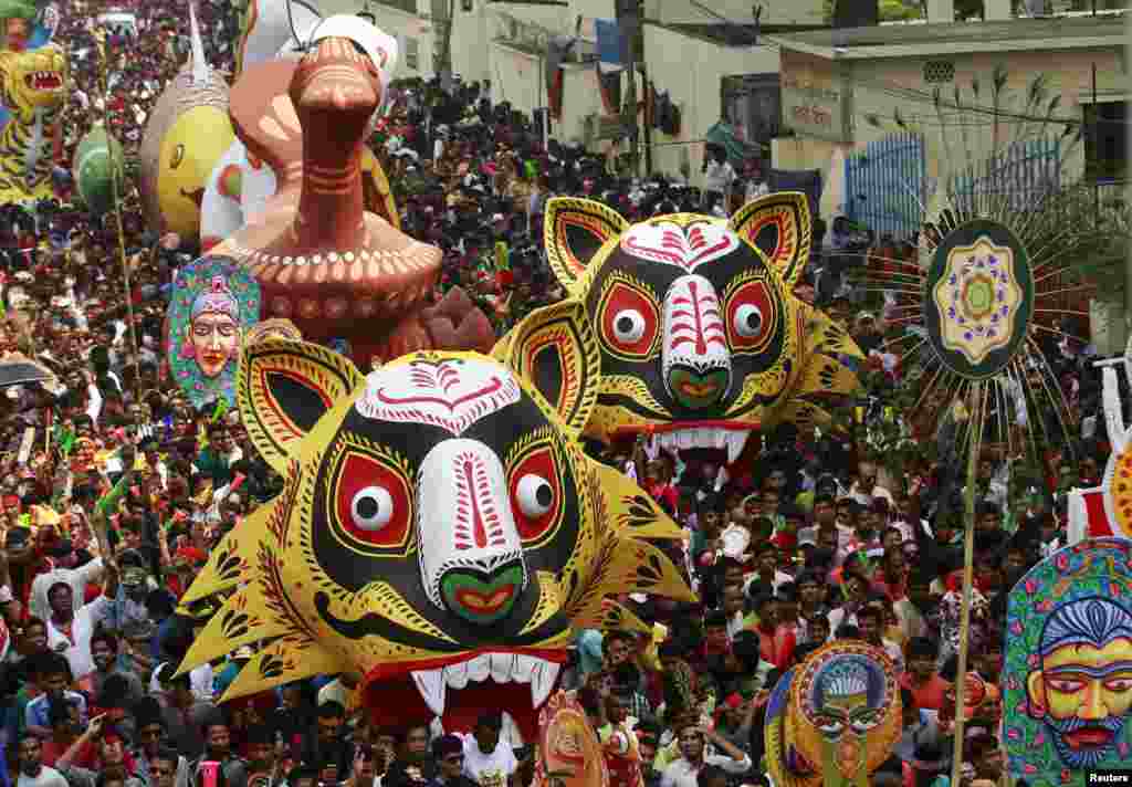 People carry masks and different animal floats down a street during celebrations on Pohela Boishakh, the first day of the Bengali new year in Dhaka.