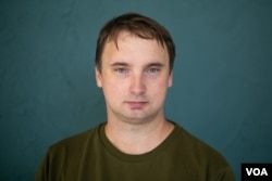 FILE - Four men successful  plain covering  detained writer  Andrey Kuznechyk extracurricular  his Minsk flat  connected  Nov. 25, 2021.